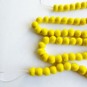 Yellow felt garland, wool balls.
